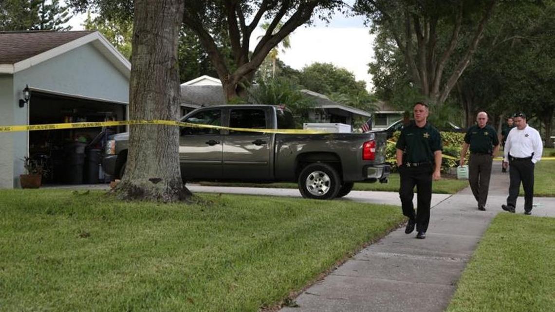 Pinellas County Sheriff's personnel walk past a vehicle located at 1635 Castlewood Lane in Palm Harbor. The Pinellas County Sheriff'ss Office is conducting a death investigation of a toddler who was found dead inside a vehicle at the residence.