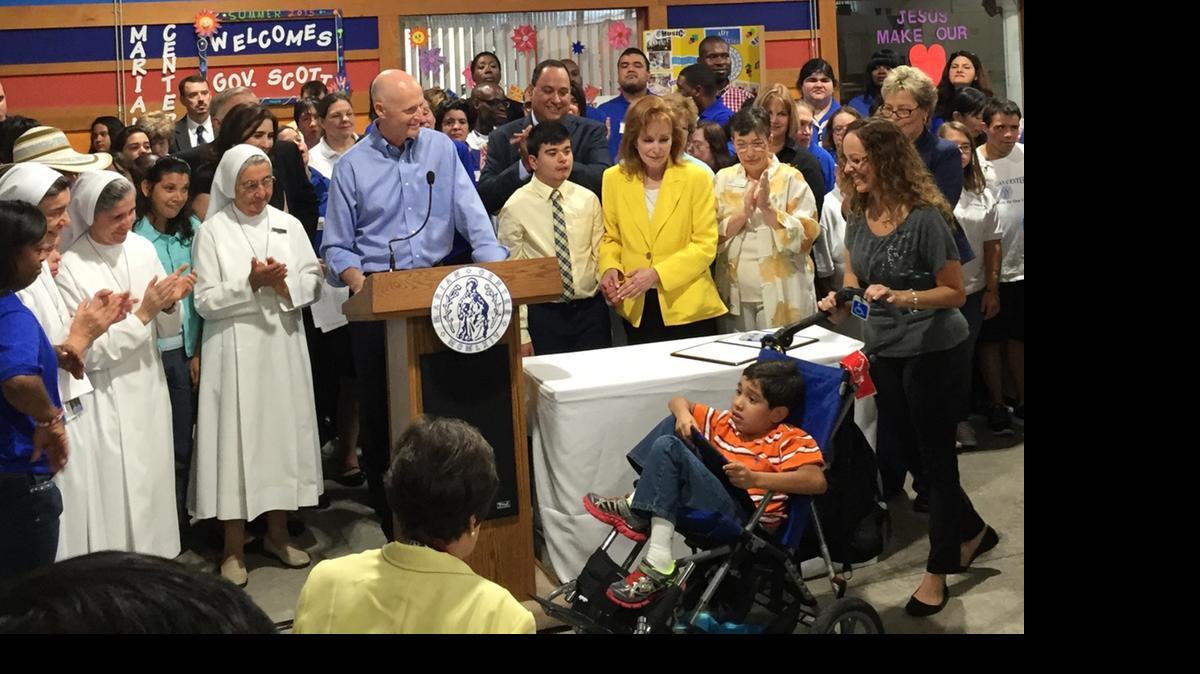 
GOOD NEWS: Fla. Gov. Rick Scott celebrates eliminating a wait list at the Marian Center, a school for people with disabilities in Miami Gardens, on Monday. Acela Ruiz, right,will begin receiving services for her 9-year-old son, Devin Feterman.
