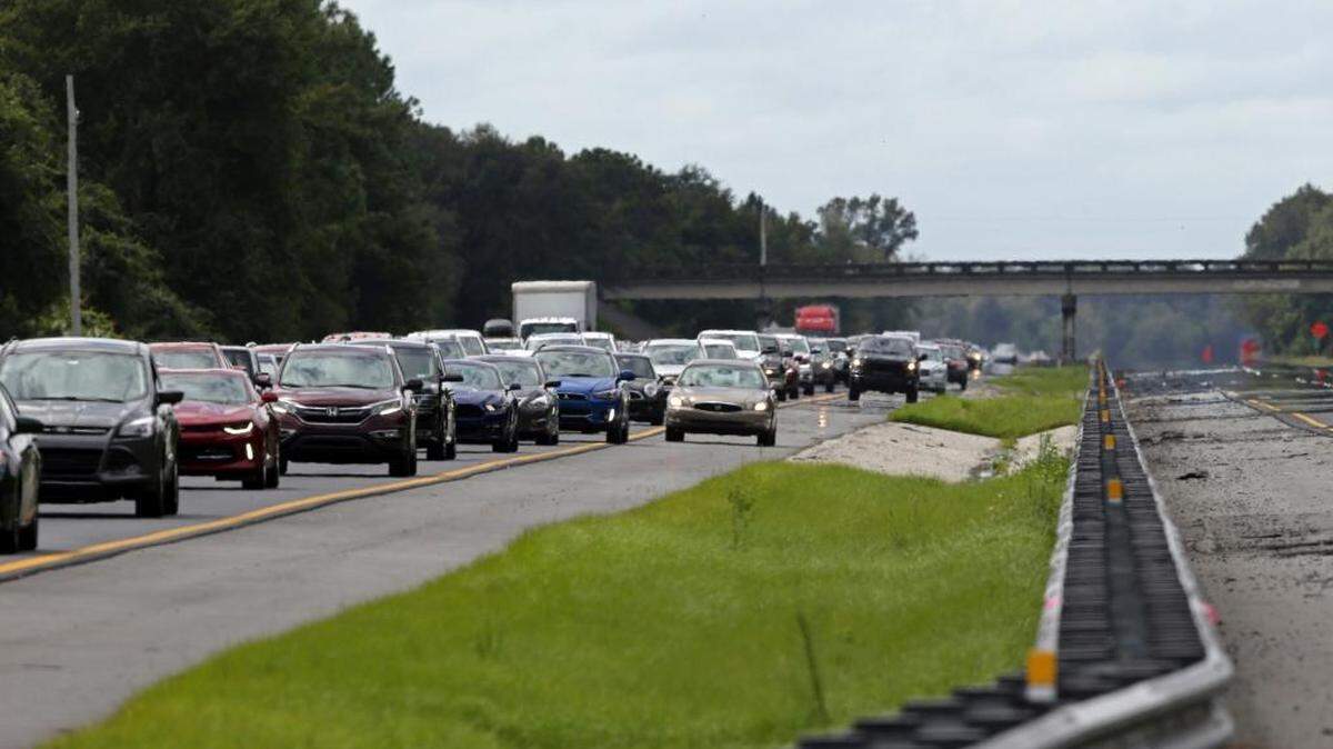 A car rides in the shoulder to pass other cars in evacuation traffic on I-75 N, near Brooksville, Fla., in advance of Hurricane Irma, Saturday, Sept, 9, 2017. With the window closing fast for anyone wanting to escape, Irma hurtled toward Florida with 125 mph winds Saturday on a projected track that could take it away from Miami and instead give the Tampa area its first direct hit from a major hurricane in nearly a century.