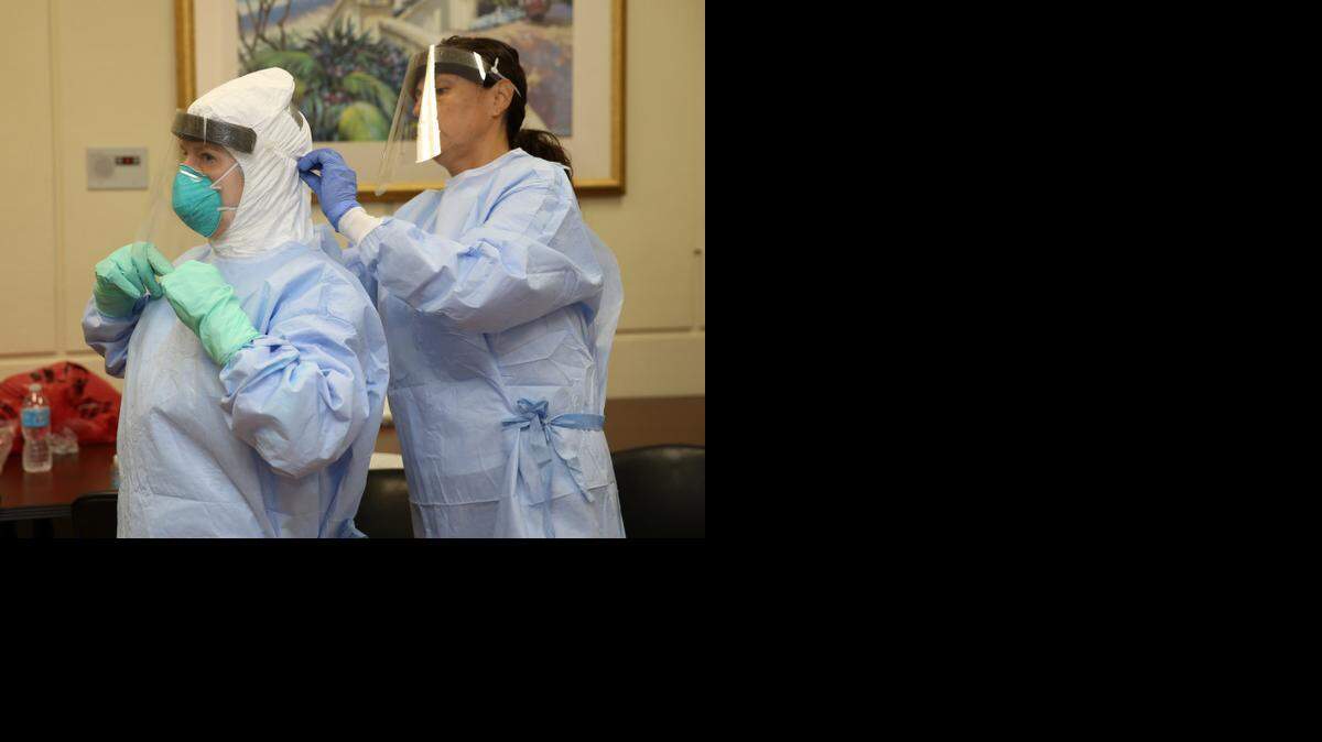 
Infection prevention and control nurses Stacy Coffman and Adriana Jimenez suit up to demonstrate the latest protocol for treating patients at risk for Ebola at Jackson Health on Monday, Oct. 27, 2014. 
