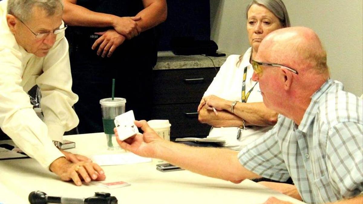 William Shearon draws the ace of clubs to win the tied Bradenton Beach mayor's election. At left is Supervisor of Elections Mike Bennett.