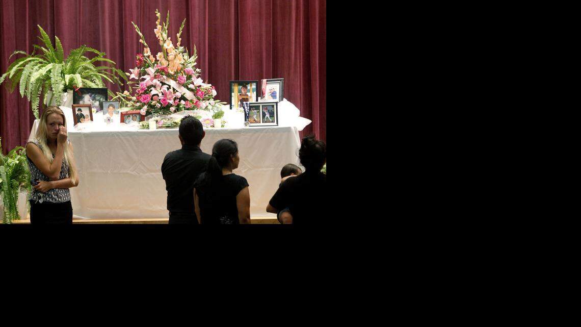 
Mourners look at a display of photos during a memorial service at Bell High School for the victims of Thursday's shootings on Sunday, Sept. 21, 2014 in Bell, Fla. Police say Don Spirit shot and killed his daughter, Sarah, and her six children before turning the gun on himself.
