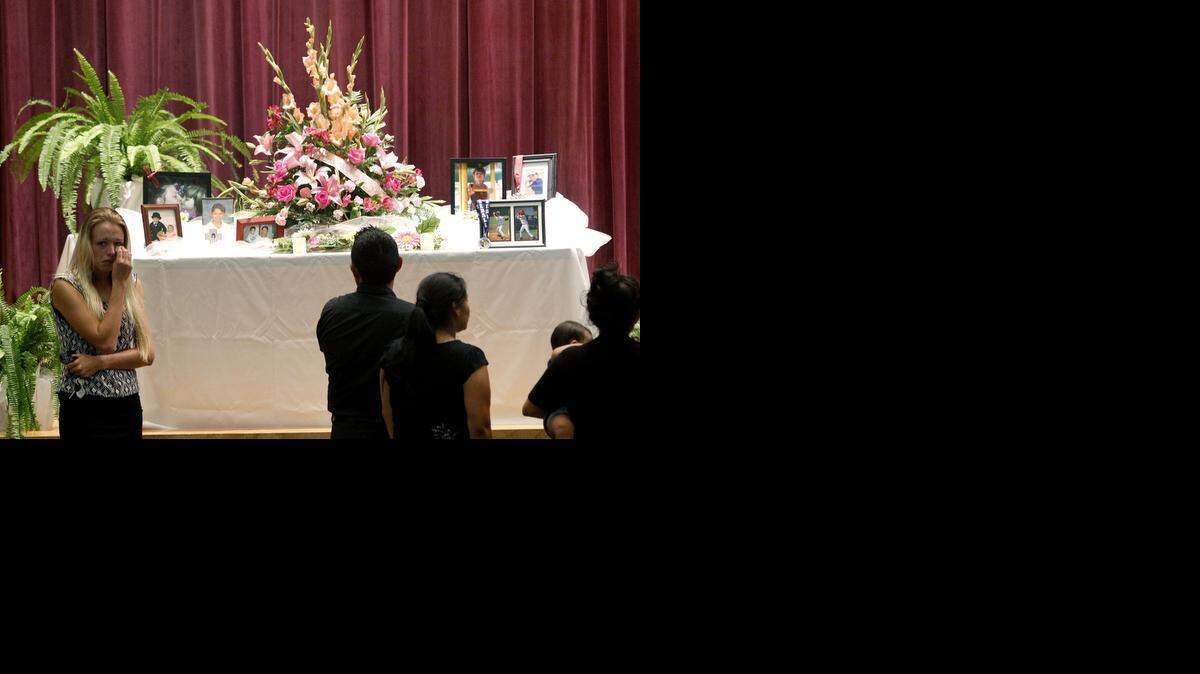 
Mourners look at a display of photos during a memorial service at Bell High School for the victims of Thursday's shootings on Sunday, Sept. 21, 2014 in Bell, Fla. Police say Don Spirit shot and killed his daughter, Sarah, and her six children before turning the gun on himself.
