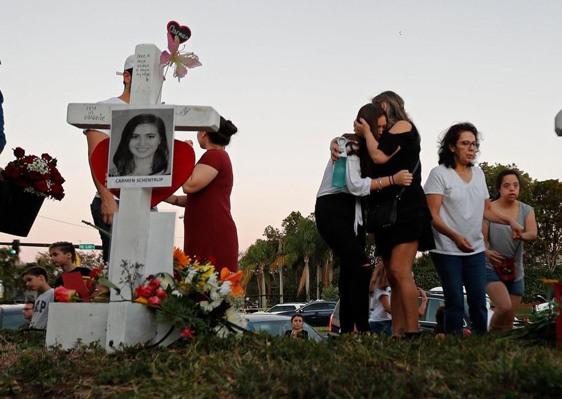 Magaly Newcomb, right, comforts her daughter Haley Newcomb, 14, a student at Marjory Stoneman Douglas High School, at a makeshift memorial outside the school on Sunday, Feb. 18, 2018.