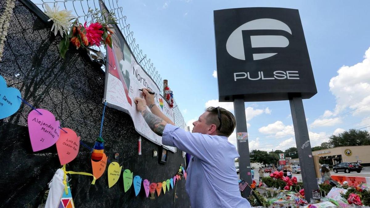 Eric Sorenson pays his respects as visitors flock to the roadside memorial at the Pulse nightclub on Wednesday, June 29, 2016, in Orlando. The city of Orlando has reached a deal to buy the Pulse nightclub and plans to transform the site of the deadliest mass shooting in U.S. history into a memorial. (Joe Burbank/Orlando/TNS)
