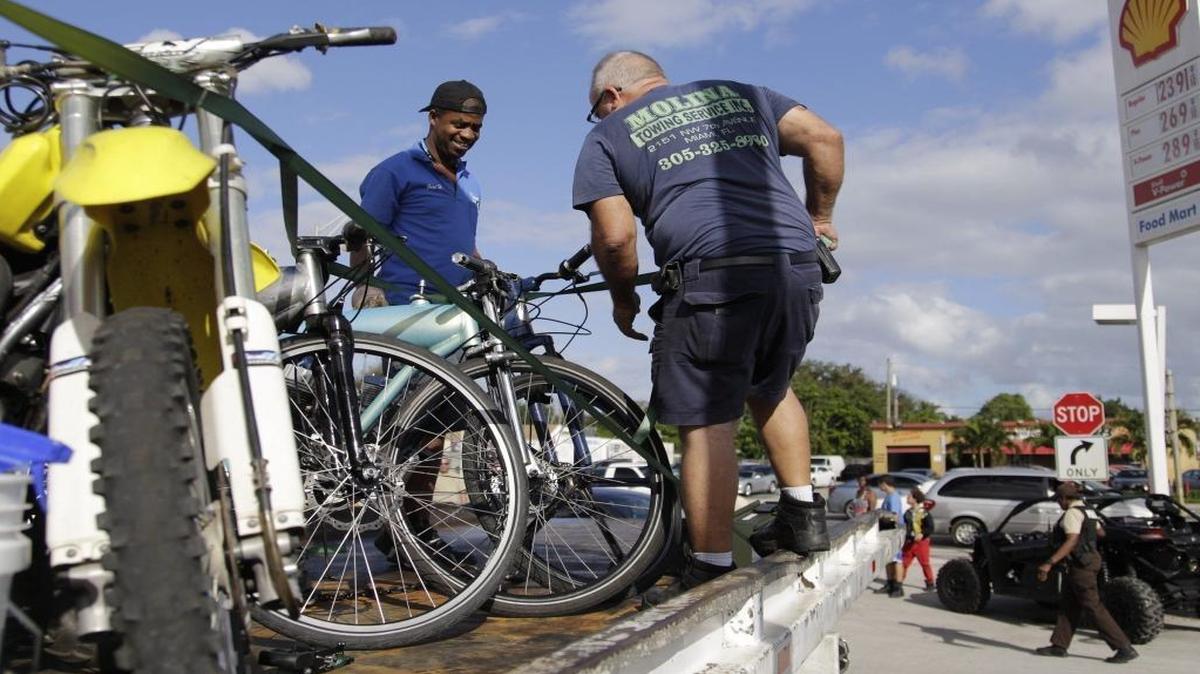 An employee of Molina Towing Service secures motorized bicycles and other vehicles on to a flatbed as Miami-Dade police impounded them as part of their operation to curtail off-road vehicles from operating in the streets and highways on MLK Day Monday, Jan. 16, 2017. The riders take to the streets for their annual Wheels Up, Guns Down ride tied to Martin Luther King Jr. Day.