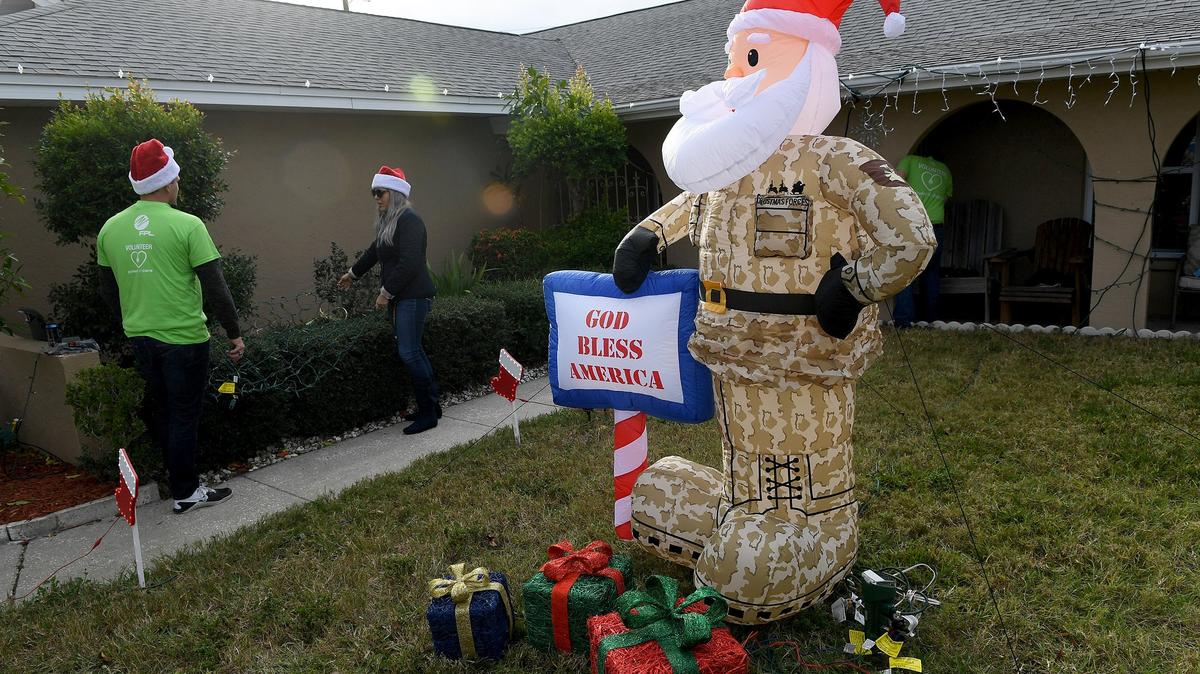 Florida Power & Light volunteers work to decorate as a Christmas surprise for a veteran and his family in Bradenton on Dec. 10, 2018.
