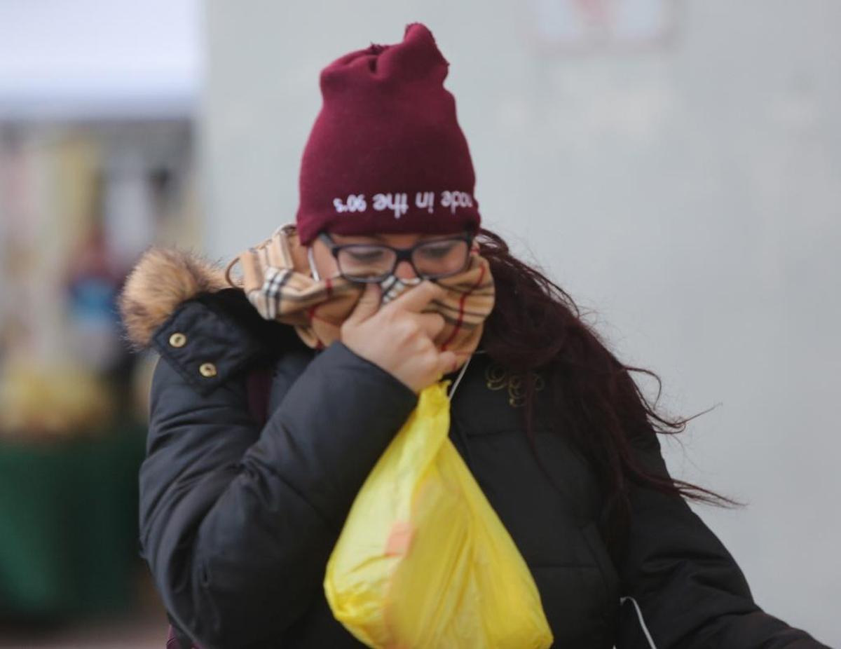 A woman covered up from the cold weather in downtown Miami during a recent cold front in the new year. Another chill, though not as severe, is expected through the Martin Luther King Jr. holiday weekend.