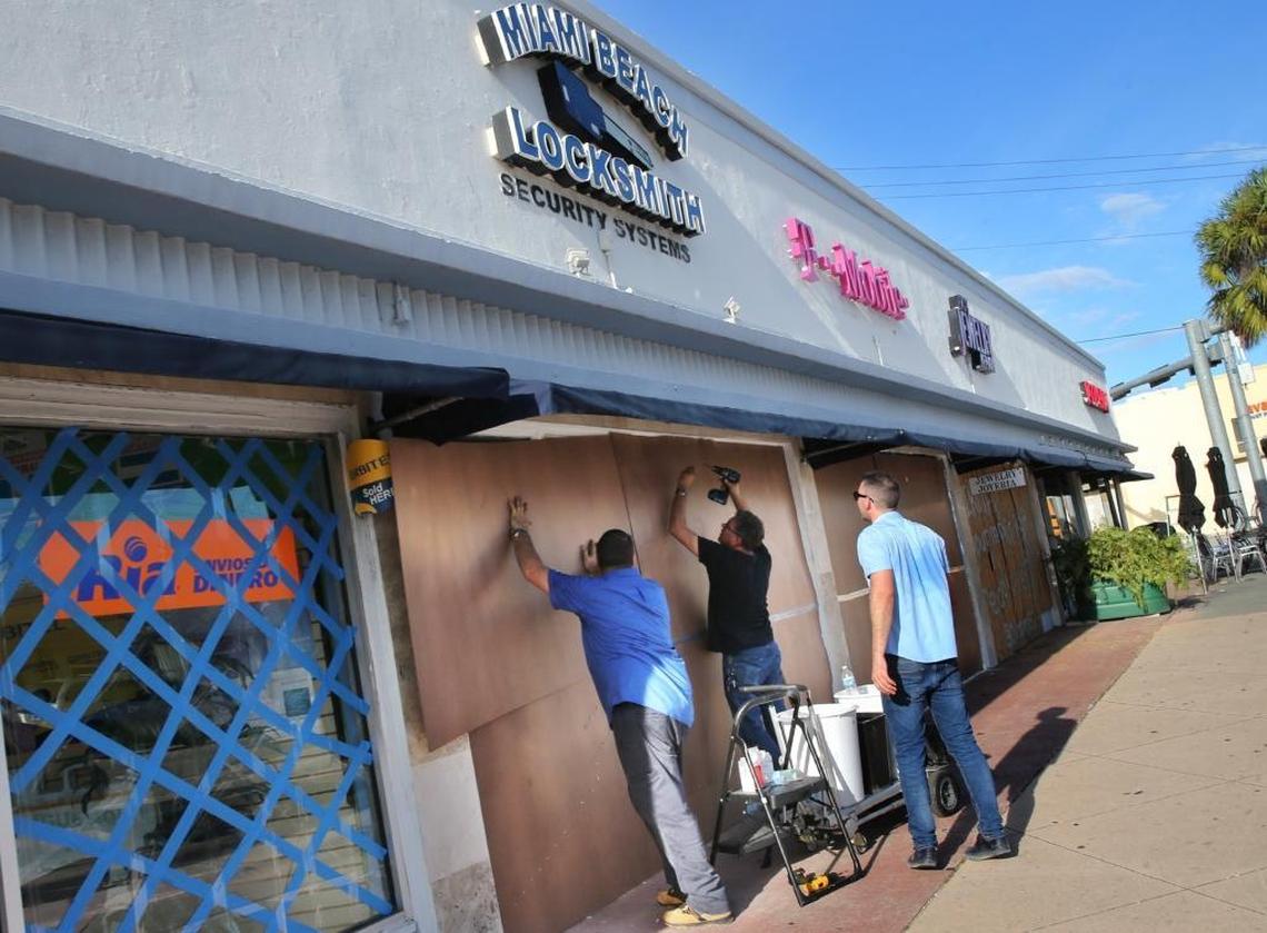 Workers Joel Gomez, Alberto Diaz and Rudy de la Paz board up the Miami Beach Locksmith store front in Miami Beach on September 07, 2017 as South Florida prepares for the coming hurricane Irma.