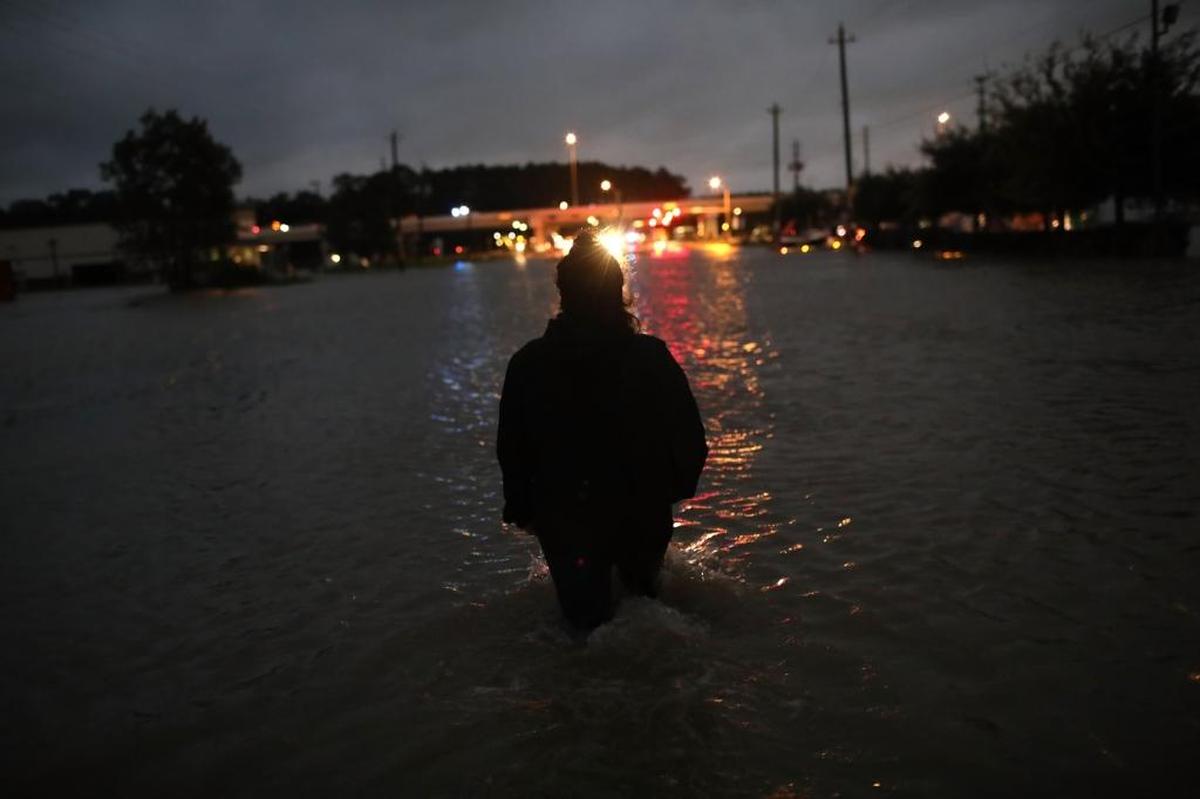 A Houston resident walks through waist deep water after fleeing her home flooded by Hurricane Harvey on Aug. 29.