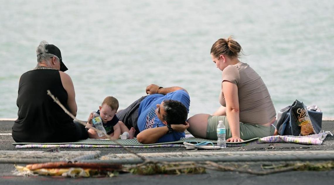 The Rodriguez family improvise a picnic on the bay in the parking lot of Shuckers Waterfront Grill on the 79th Street Causeway because they were not allowed back into South Beach where they live and can’t find a motel anywhere in Miami.