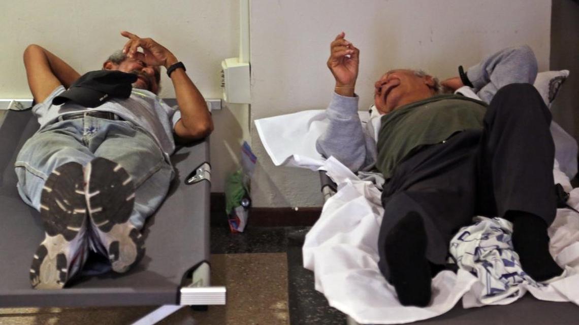 Two men share a laugh as they and other residents of Old San Juan take advantage of the open hurricane shelter at City Hall in advance of Hurricane Maria in Puerto Rico on Tuesday.