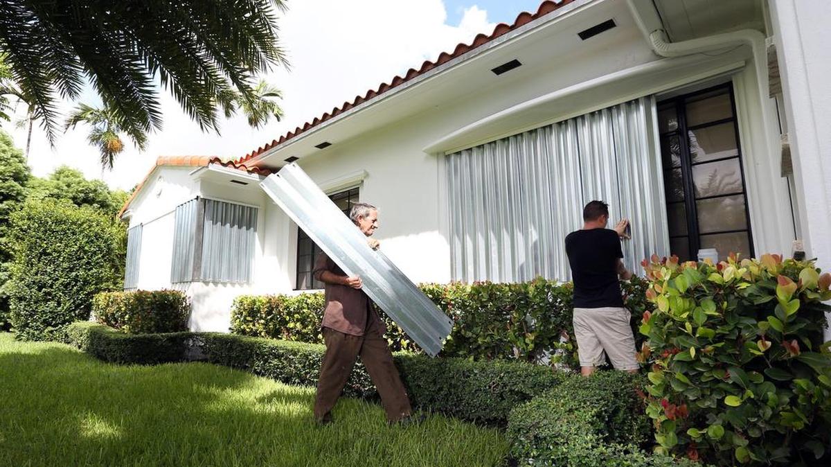 Manuelito Hervas and Federico Rodriguez work to put aluminum shutters up on a home along NE 95th St. near NE 12th Ave. in MIami Shores on Sept. 6, 2017 in preparation for Hurricane Irma.