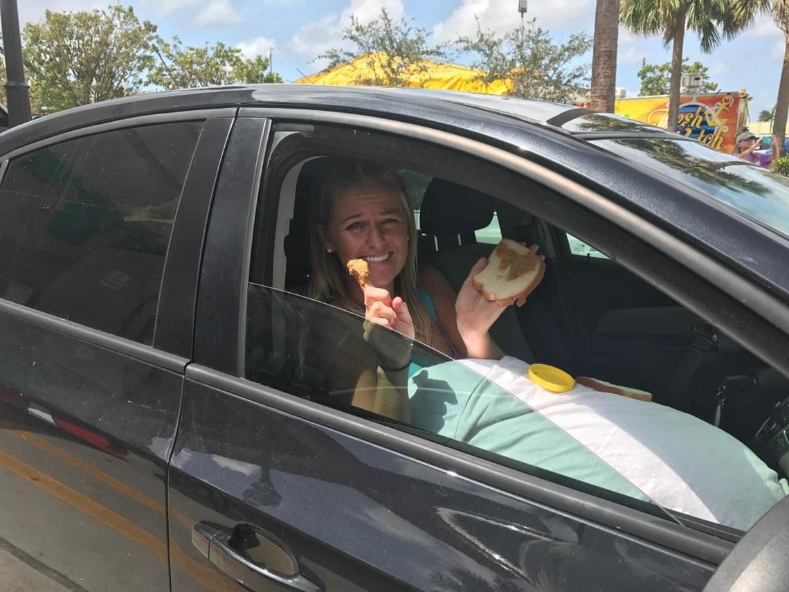 Amber Roelof, who is five months pregnant, eats peanut butter with her finger as she waits in the parking lot of the Race Trac gas station in Florida City on Monday, Sept. 11, 2017. She and her fiance left the Florida Keys on Saturday to escape Hurricane Irma and waited with dozens of others to return to their homes in the Keys. Police have closed off the roads entering the Keys due to storm debris.