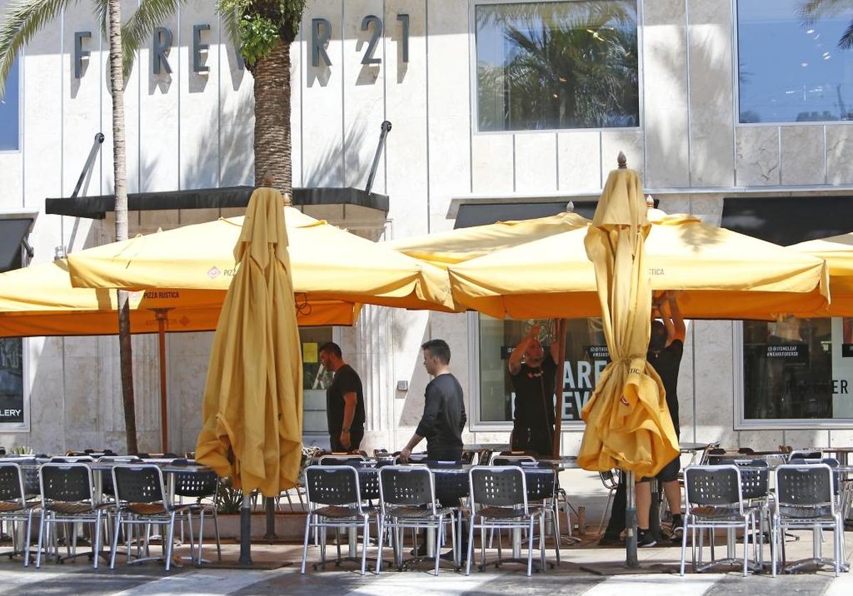 Pizza Rustica employees setting up the tables on Lincoln Road Tuesday before opening.