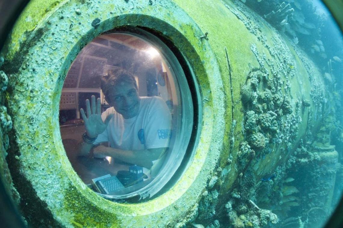 Fabien Cousteau waves from inside Aquarius Reef Basein June 2014. A team of filmmakers and researchers accompanied Cousteau to study the effects of climate change.