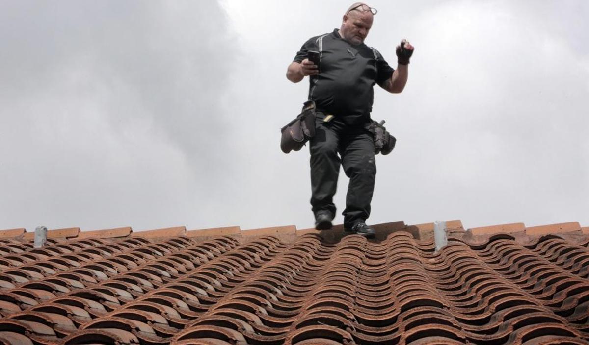 Catastrophic claims specialist Eric Kline inspects the roof of a house in Kendall in 2017.