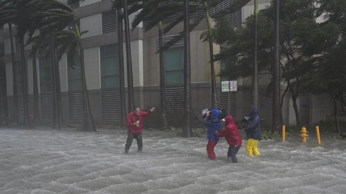 A television crew endures Irma’s wind and rain while broadcasting from a flooded street in downtown Miami on Sept. 10.