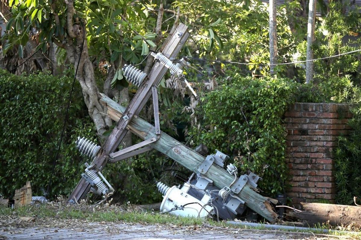 A broken utility pole lies on the ground as utility workers from out-of-state fix power lines knocked down by trees and branches in Coral Gables on Saturday, September 16, 2017.