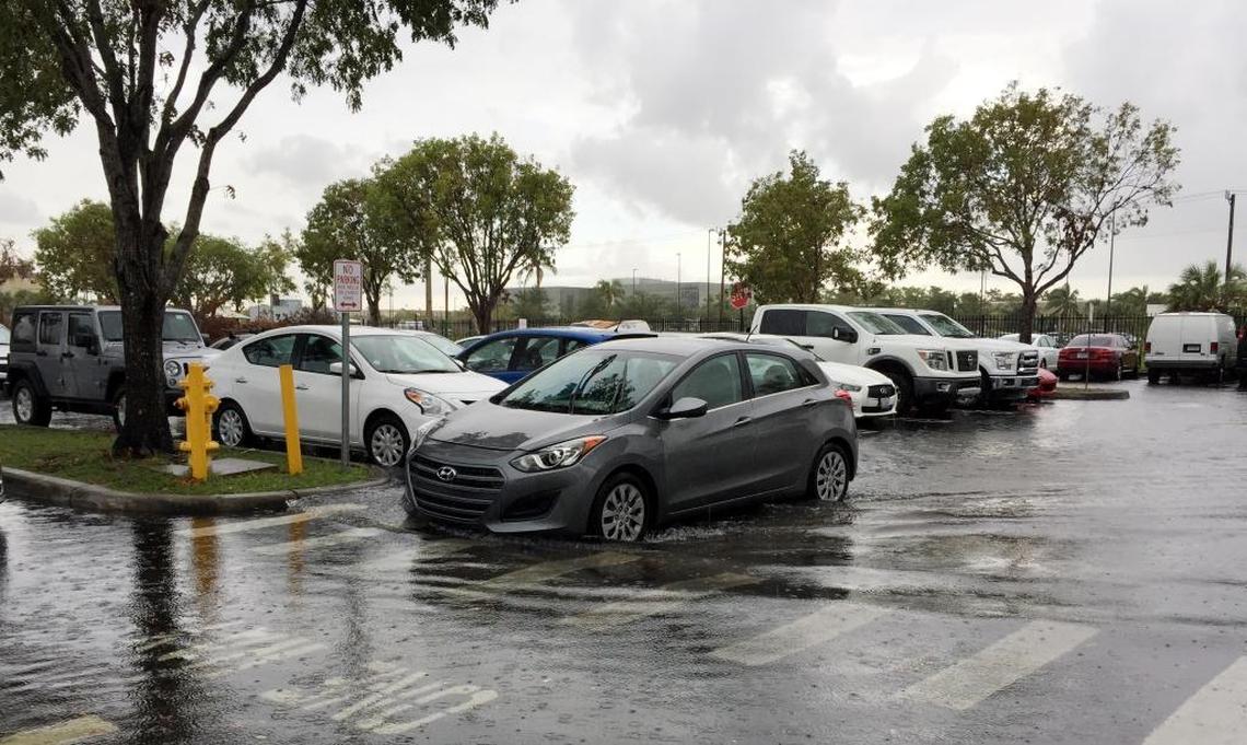 A car makes its way through the flooded Miami Herald parking lot Friday, Sept. 22, 2017, in Doral.