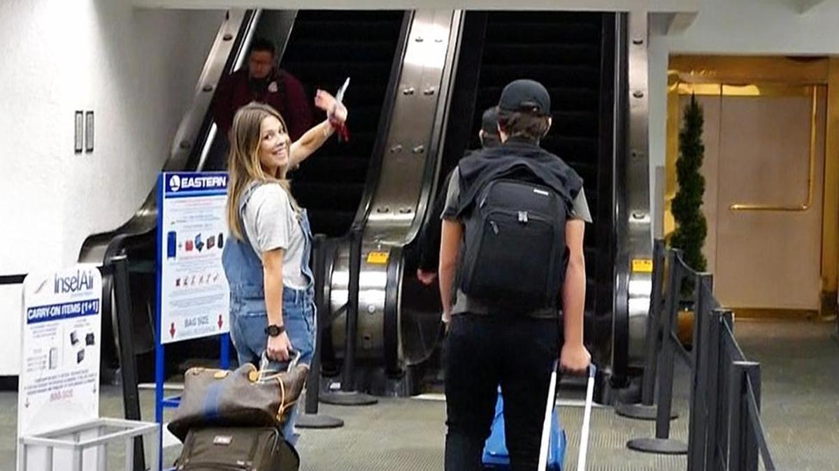Stranded Venezuelan passenger Francoise Viera happily waves goodbye as she enters the terminal to board a flight via Pawa Airlines after being stranded for three days at Miami International Airport.