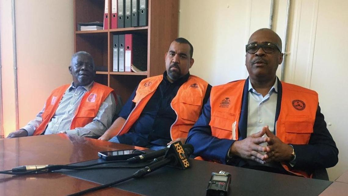 During a news conference at the Emergency Center in Port-Au-Prince, Haiti, Prime Minister Jack Guy Lafontant (right) addresses local reporters as Max Rudolph Saint-Albin, minister of the interior (center) and Hervé Denis, minister of defense (left), look on.