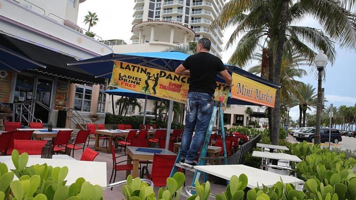 Owner Ronie Mualem removes signs of his Roni's by the Ocean restaurant as he prepares for the possible impact of Hurricane Irma in Miami Beach on September 06, 2017.