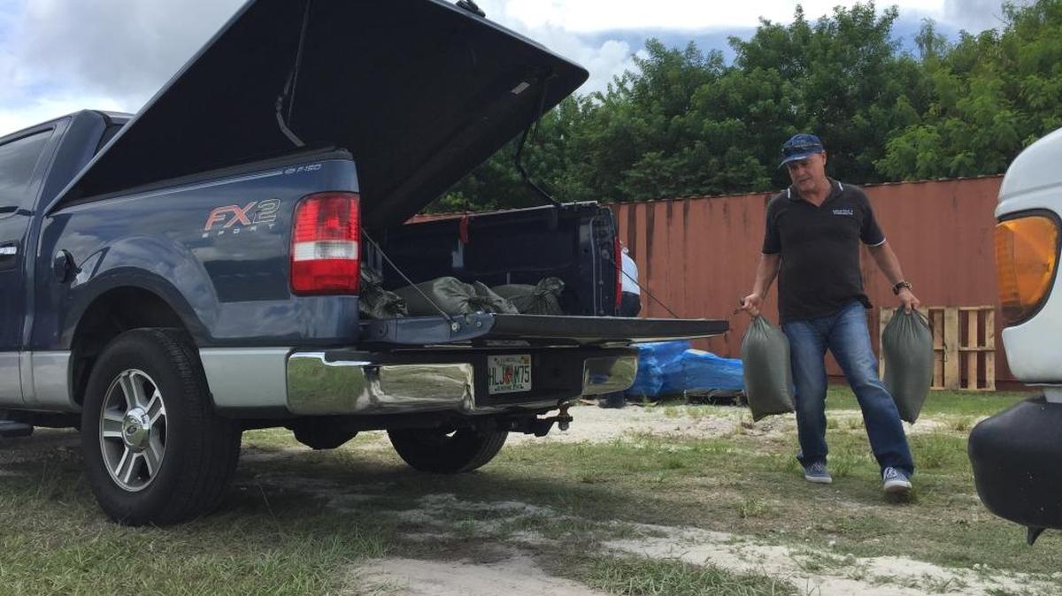 Nelson Vazquez loads up 10 free sand bags at Doral Central Park on Wednesday, Sept. 6, 2017. He waited in line over three hours for the bags.