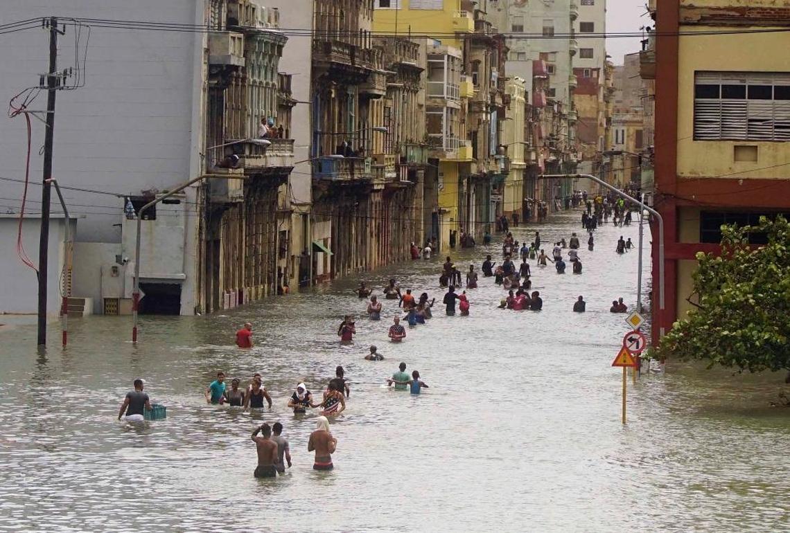People move through flooded streets in Havana after the passage of Hurricane Irma on Sept. 10, 2017. The powerful storm ripped roofs off houses, collapsed buildings and flooded hundreds of miles of coastline.