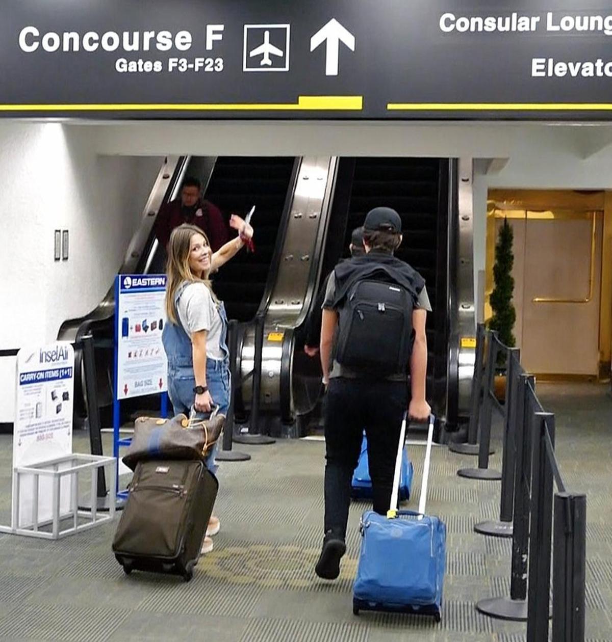 Venezuelan passenger Francoise Viera waves goodbye at the terminal at Miami International Airport before boarding a flight to the Dominican Republic, where she was finally able to connect to a flight to Caracas.