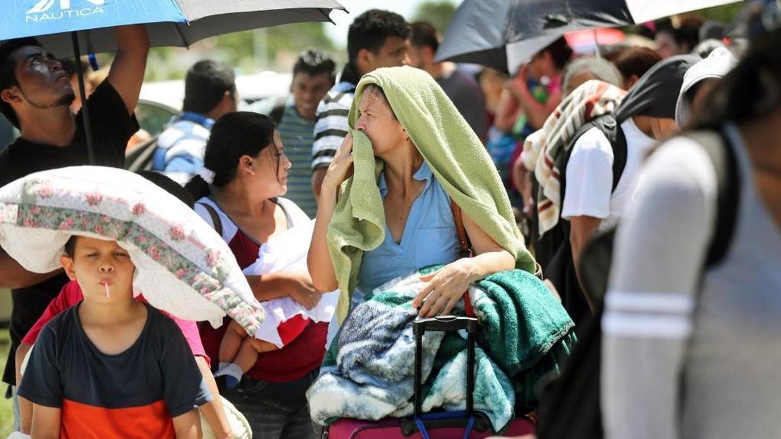 Hurricane Irma evacuees wait in line in the scorching sun for hours before entering into Robert Morgan Educational Center, which immediately was filled to capacity of 2,400 people on Friday, Sept. 8, 2017
