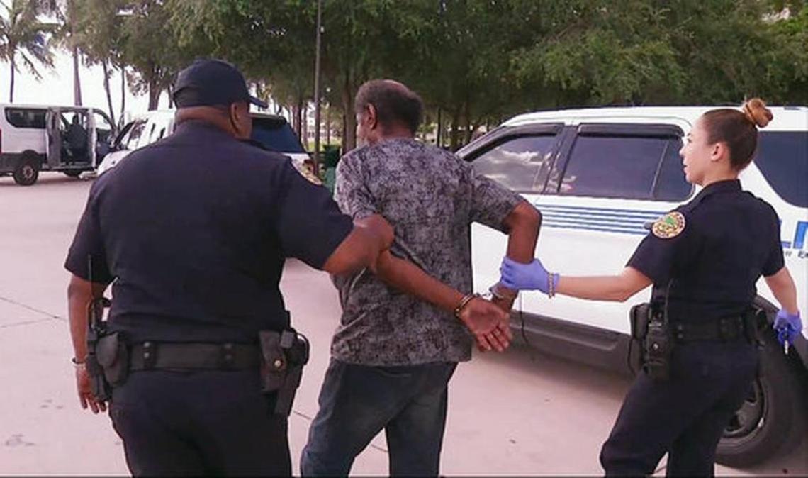 In this frame made from video on Fri., Sept. 8, 2017, officials in Miami detain a person who is homeless into shelters ahead of powerful Hurricane Irma. Officials detained at least five people to admit them into a psychiatric ward because they suspected a mental illness.