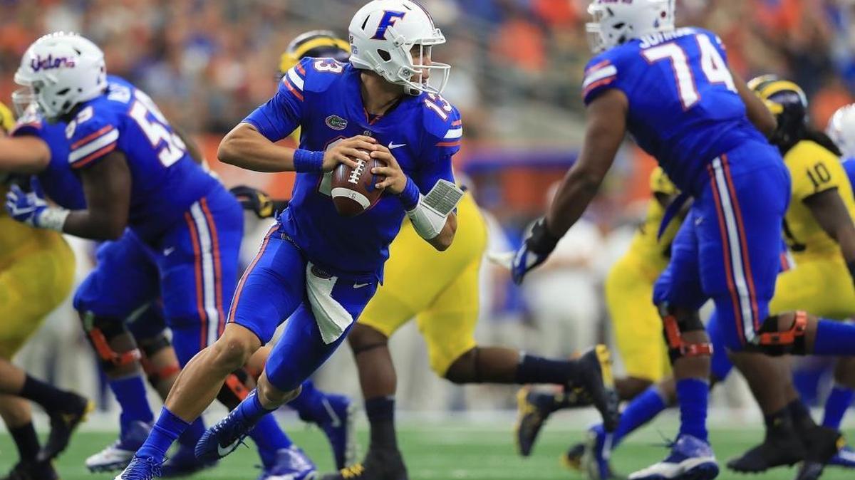 Feleipe Franks (13) of the Florida Gators scramble in the pocket against the Michigan Wolverines in the first half of a game at AT&T Stadium on September 2, 2017 in Arlington, Texas.