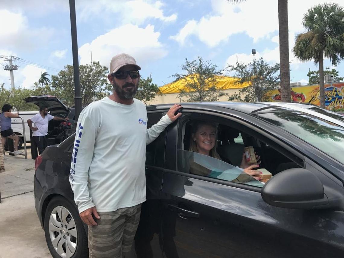 Shelby Bentley stands beside his car while his fiancé Amber Roelof sits inside. They were waiting with dozens of others Monday morning for police to let them return to their homes in Monroe County. The two fled Cudjoe Key Saturday morning; Hurricane Irma made landfall on Cudjoe Key early Sunday. They have been waiting in Florida City since 1 a.m. Monday, Sept. 11, 2017.