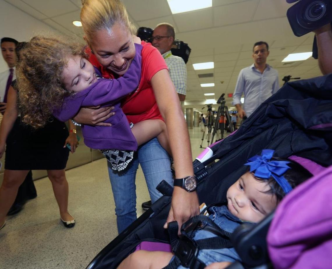 Mara Moreno greets her grandchildren Wilyanielis, 3, and 6-month-old Ainhoa at Miami International Airport.