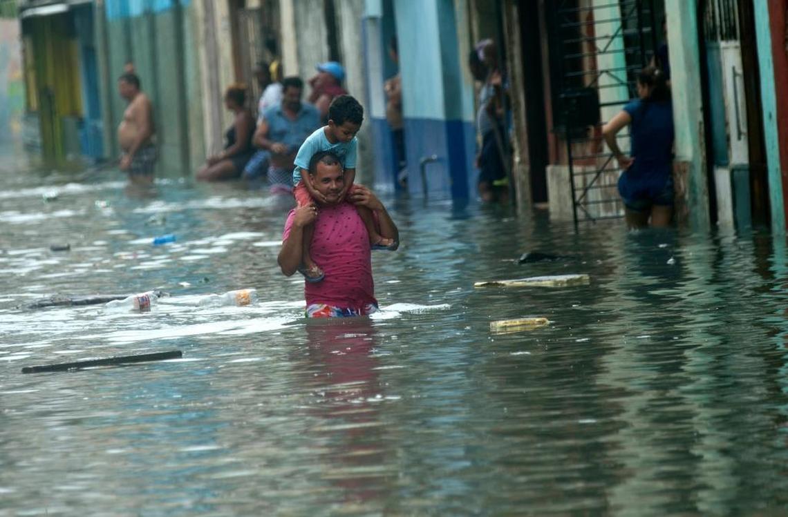 A man carries a child on his shoulders as he walks on a flooded street in Havana, after the passing of Hurricane Irma in Cuba on Sunday. The powerful storm ripped roofs off houses, collapsed buildings and flooded hundreds of miles of coastline.