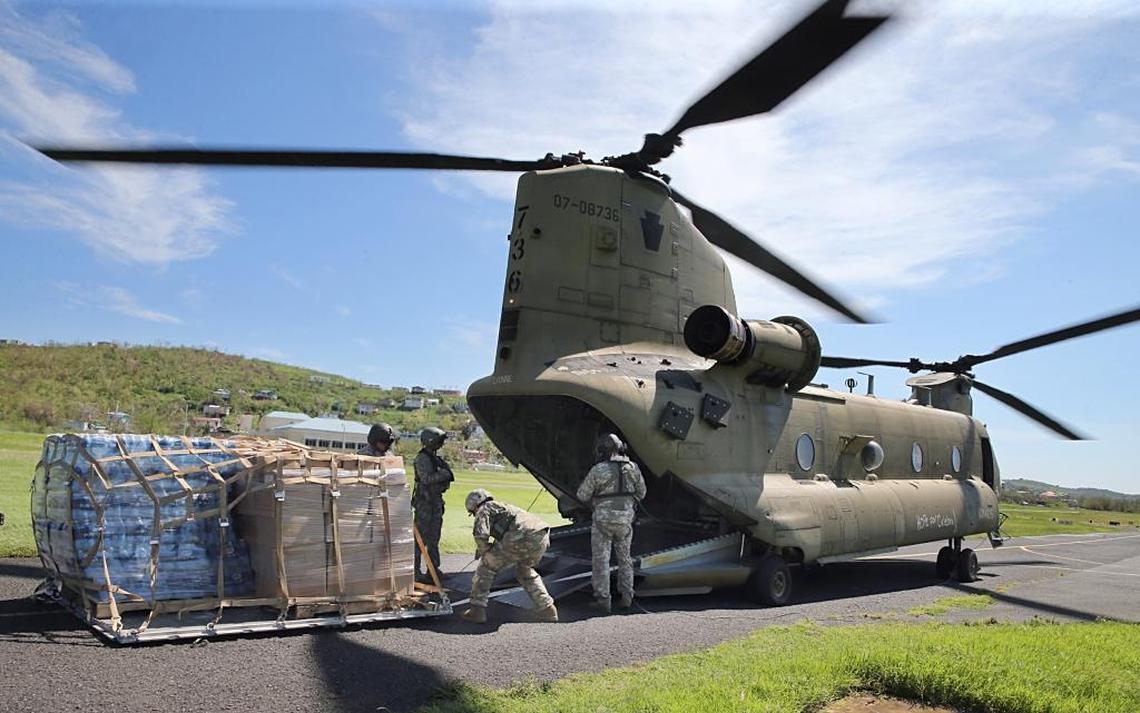 A group of U.S. Air Force members unload an electrical generator and other relief supplies from a Chinook Helicopter after landing in the island of Culebra, Puerto Rico, in the aftermath of Hurricane Maria,