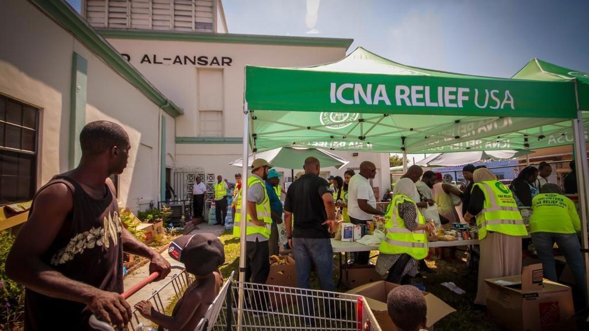 Iraq War veteran Antoine Cooper, left, and his two boys arrive at the Masjid Al-Ansar mosque in Miami, Fla., which is giving food to residents of Liberty City effected by Hurricane Irma.