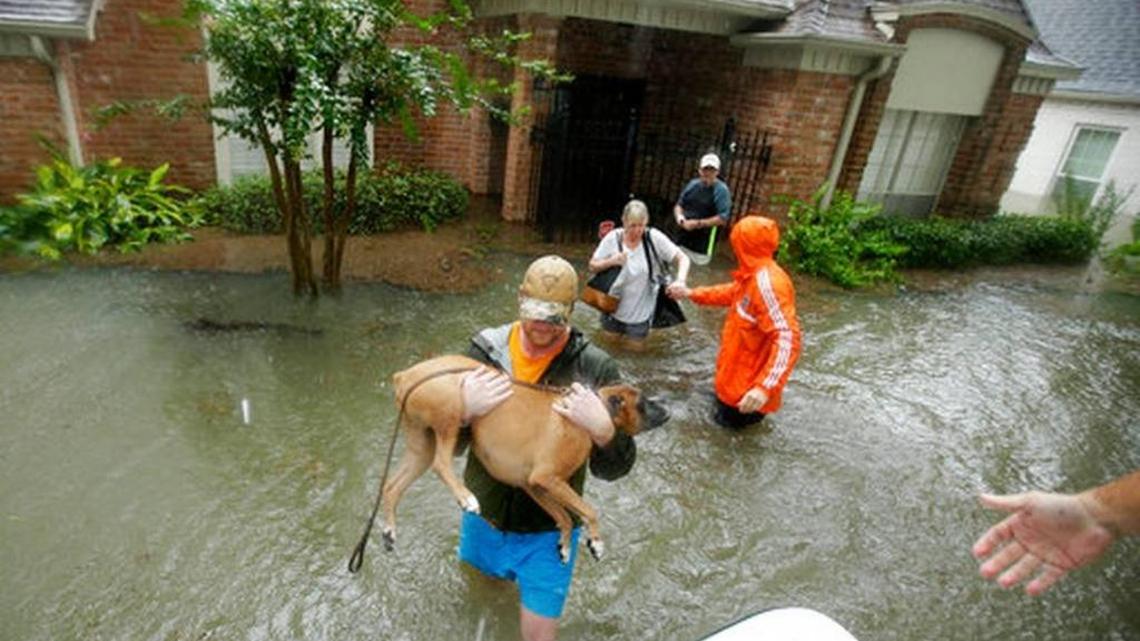 Volunteers evacuate a neighborhood inundated by floodwaters from Tropical Storm Harvey on Monday, Aug. 28, 2017, in Houston.
