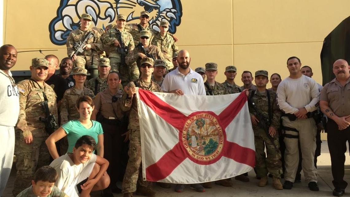 Redland Middle School principal Gregory Beckford (left) and South Dade Middle School principal John Galardi (center) pose with schools police, National Guardsmen, Miami-Dade police and Red Cross volunteers who helped keep the shelter running during Hurricane Irma.