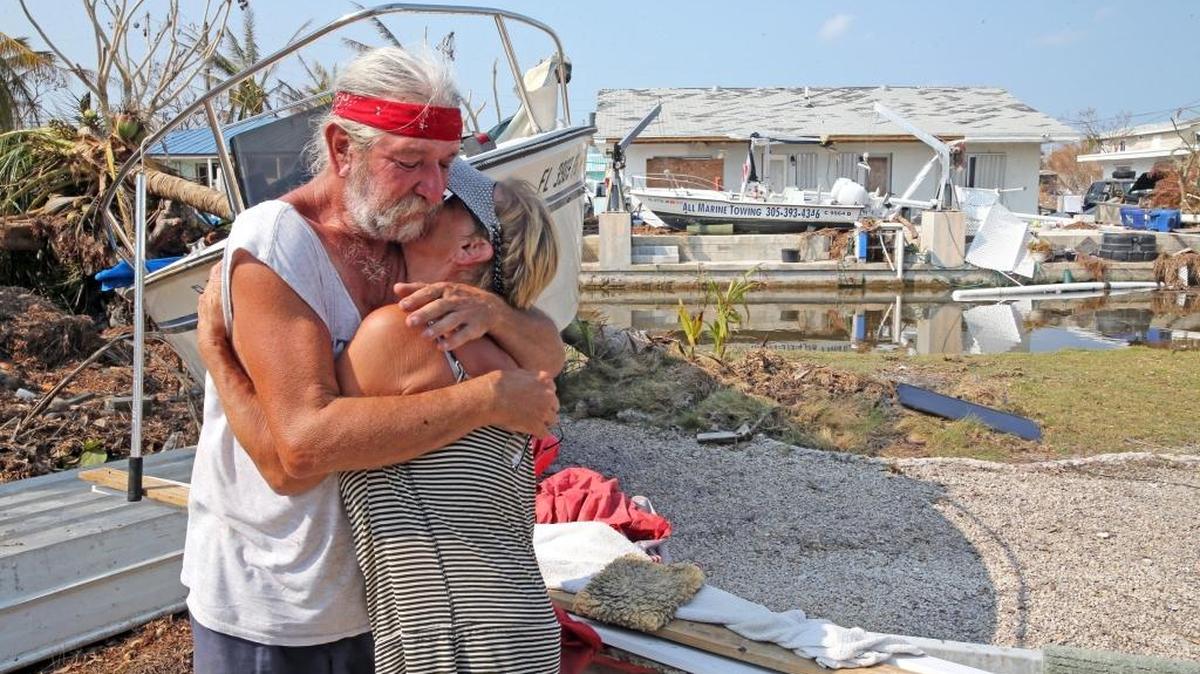David and Dee Thorne hug near their home on Big Pine Key in the Florida Keys, their home was damaged during Hurricane Irma on Sept. 20. They are living in an RV on the lot as they begin to repair the house.