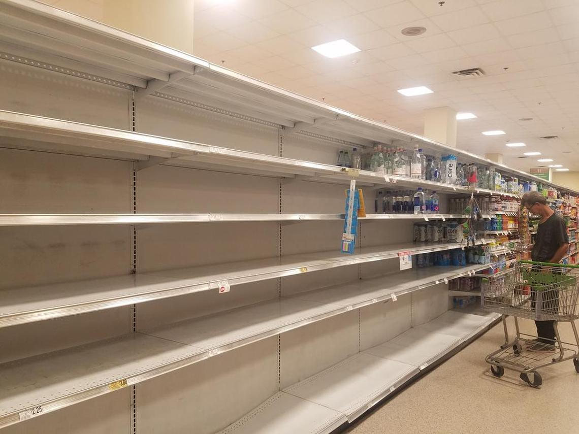 A shopper browses the mostly empty shelves in the water aisle at a Publix in Coral Gables. Shoppers rushed to stores on Labor Day in preparation for Hurricane Irma.
