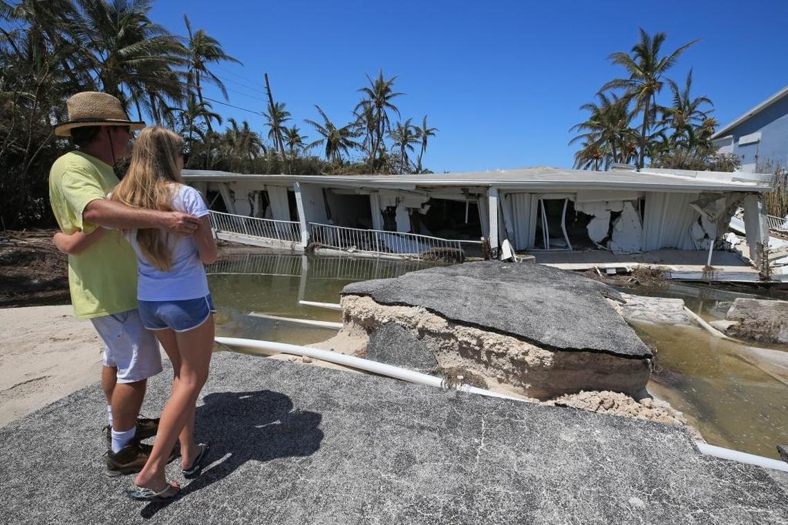 Mike Gilbert and his daughter Brook Gilbert, 15, stand over the remnants of a three-story Sandy Cove condo located in Lower Matecumbe Key in the town of Islamorada.