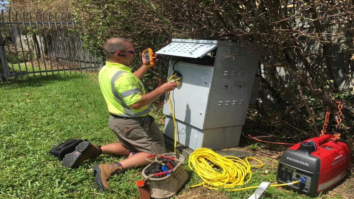 A Comcast technician checks power levels and installs a generator to power up equipment and provide service to a Kendall neighborhood.