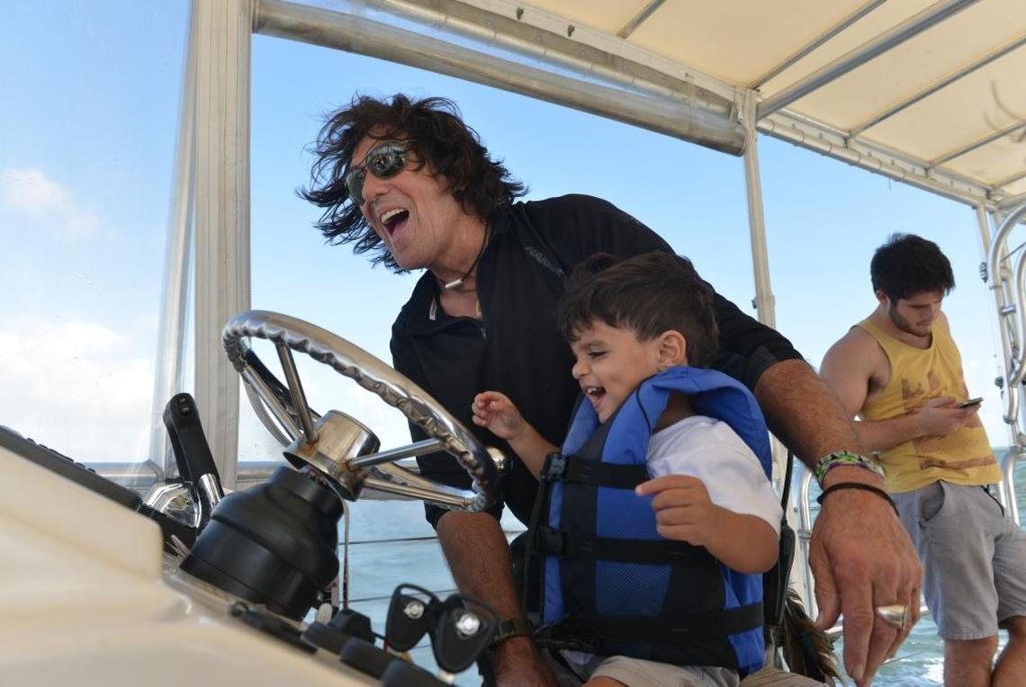 Shake-A-Leg director and manager Craig Kirk let Kaleb Abreu, then-2, steer during a Shake-A-Leg Miami-hosted Community Abilities Bay Day with UM Athletes and Youth with Disabilities along South Bay Shore Drive, Coconut Grove, Fla., on Sunday, Dec. 8, 2013.