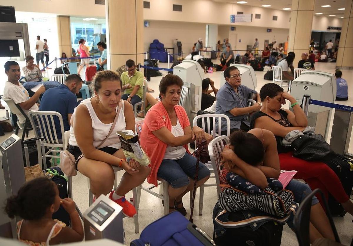 Crystal Garcia and Evelyn Torres (L-R) wait in line to get a United Airlines flight out of the Luis Munoz Marin International Airport as they try to escape the conditions after Hurricane Maria passed through the island on September 25, 2017 in San Juan Puerto Rico. Some of the people have waited days at the airport in hope of getting onto a plane after Hurricane Maria, a category 4 hurricane, passed through.