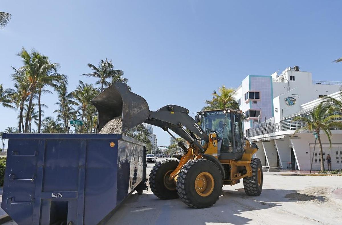 Miami Beach workers on Tuesday began the process removing sand that washed up on Ocean Drive during Hurricane Irma.