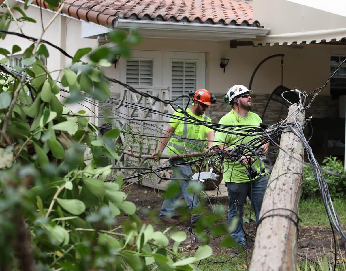 Trabajadores de servicios públicos inspeccionan líneas eléctricas derribadas por árboles y ramas en Coral Gables el sábado 16 de septiembre de 2017.