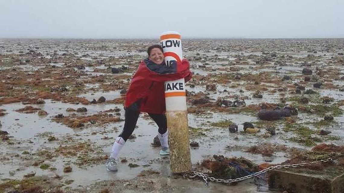 A woman holds on to a NO WAKE buoy in a drained Buttonwood Bay in Key Largo before Hurricane Irma arrived.