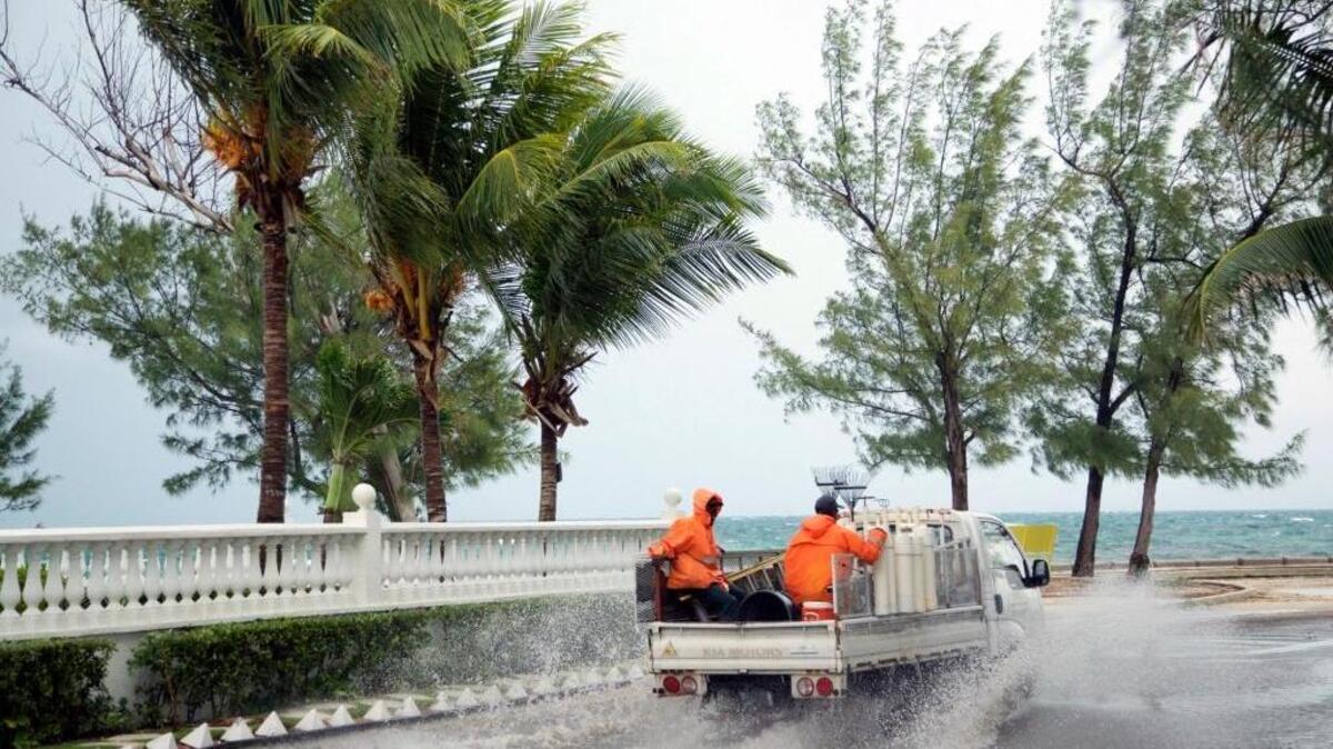 Landscapers ride in a truck along a stretch of road that's partially flooded from rain triggered by the arrival of Hurricane Matthew, in the eastern district of Nassau, Bahamas, Wednesday, Oct. 5, 2016. Forecasters said the storm was on track to roll directly over the capital city before nearing the Florida coast.